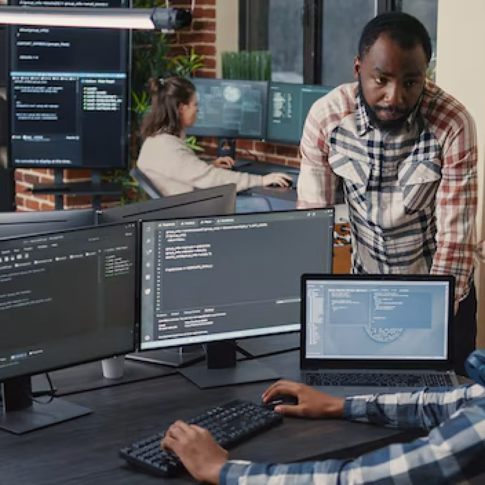 programer-sitting-desk-with-multiple-screens-running-code-talking-with-colleague-about-artificial-intelligence-algorithm-software-developers-doing-innovative-artificial-intelligence-project_482257-40606 programer-sitting-desk-with-multiple-screens-running-code-talking-with-colleague-about-artificial-intelligence-algorithm-software-developers-doing-innovative-artificial-intelligence-project_482257-40606